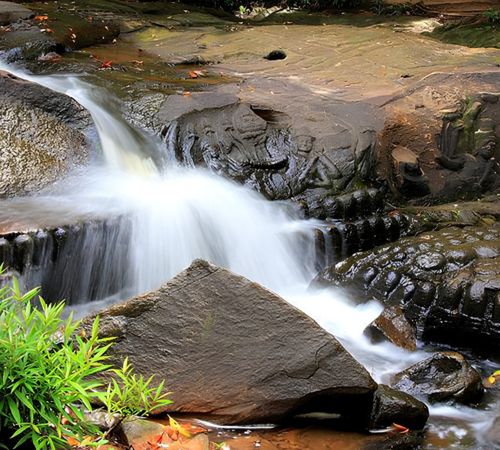 A waterfall flowing over ancient stone linga carvings at Kbal Spean or Phnom Kulen National Park near Blanc Smith Hotel in Siem Reap.