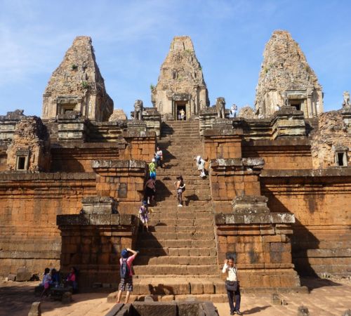 An ancient multi-tiered sandstone and brick temple pyramid during a guided Siem Reap historical excursion.