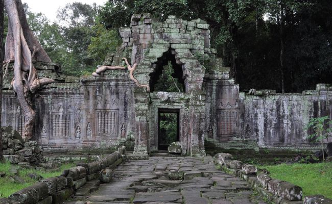 Ancient stone gopura gateway and causeway of Preah Khan temple surrounded by jungle trees during a guided Grand Circuit tour in Siem Reap.