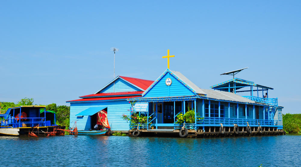 A vibrant blue floating church on the water during a Tonle Sap Lake floating village tour near Blanc Smith Hotel in Siem Reap.