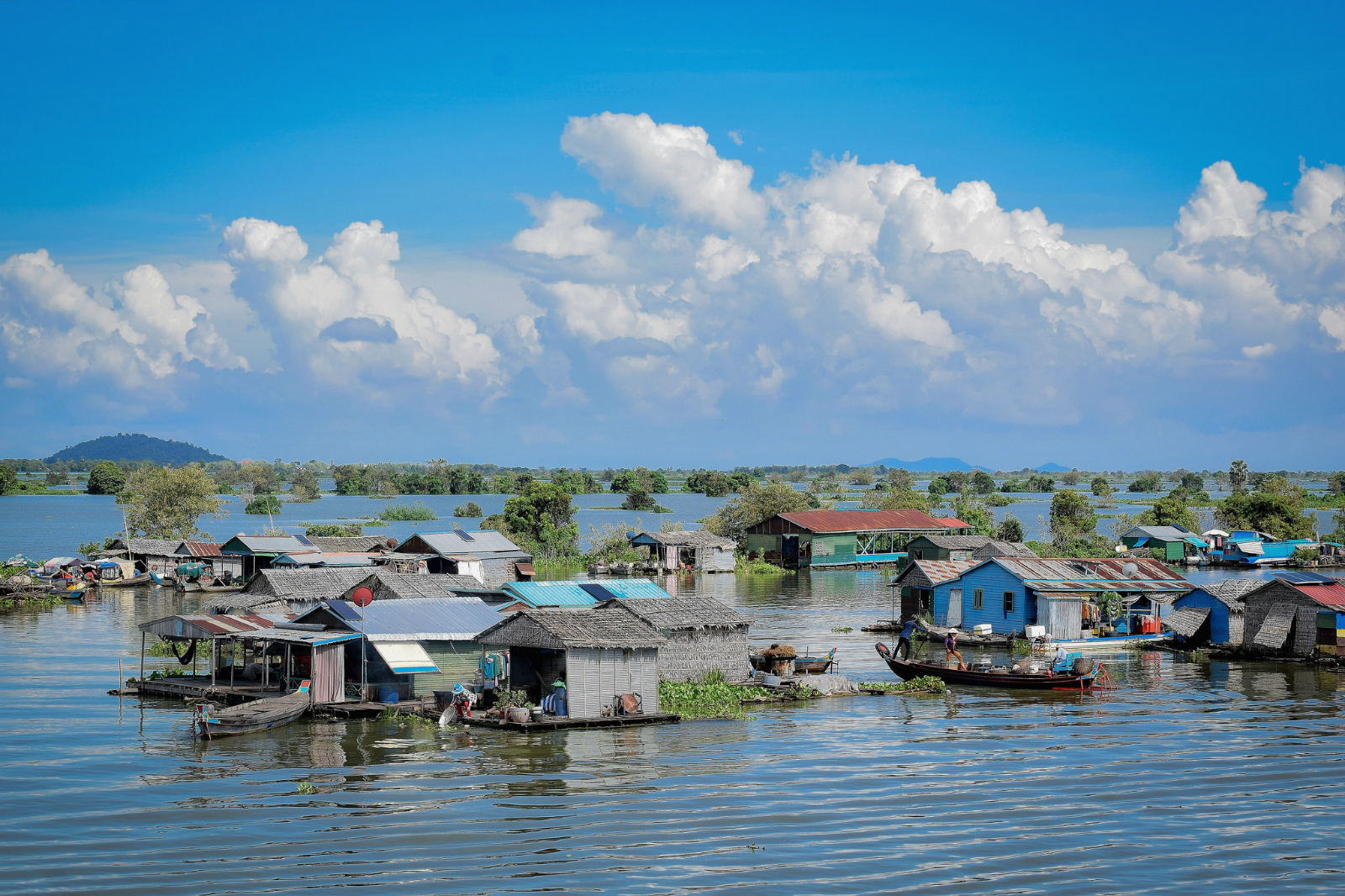 Traditional floating houses and local fishing boats clustered on Tonle Sap Lake in Siem Reap.